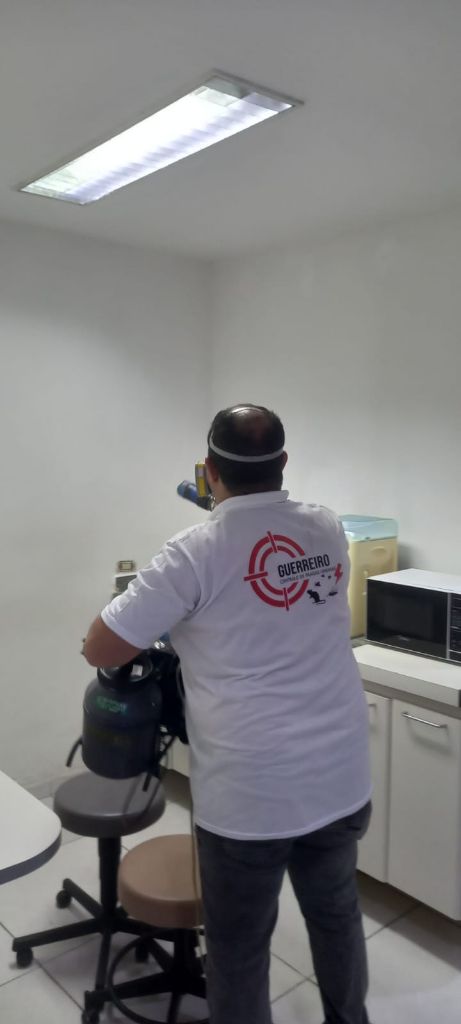 Profissional realizando nebulização em área comercial